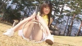 Wajah boneka sayang berpose di kamera mengenakan seragam tenis